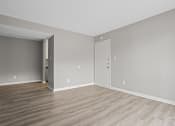 Thumbnail 6 of 25 - an empty living room with wood floors and grey walls