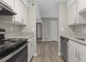 Thumbnail 2 of 25 - a kitchen with granite counter tops and stainless steel appliances