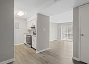 Thumbnail 4 of 25 - the spacious kitchen and living room of a renovated apartment with white appliances and wood floors