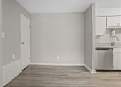 Thumbnail 7 of 25 - an empty room with a kitchen and a sink and a refrigerator