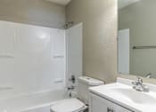 Thumbnail 25 of 27 - A white bathroom with a toilet, sink, and bathtub.