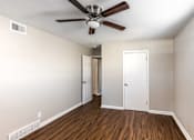 Thumbnail 18 of 27 - A room with a ceiling fan and wood flooring.