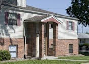 Thumbnail 3 of 27 - A house with a white siding and a brick facade with a brown door.