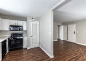 Thumbnail 7 of 27 - A kitchen with white cabinets and a black stove top oven.