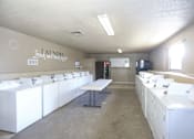 Thumbnail 27 of 27 - Laundry and dryer room with white washers and dryers.