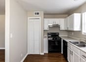 Thumbnail 12 of 27 - an empty kitchen with white cabinets and black appliances