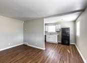 Thumbnail 15 of 27 - an empty living room and kitchen with wood flooring