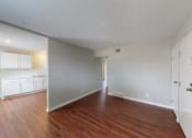 Thumbnail 8 of 27 - an empty living room and kitchen with wood floors