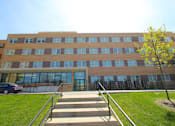 Thumbnail 2 of 3 - A large building with a tree in front of it.