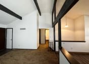Thumbnail 15 of 26 - a living room with white walls and exposed wood beams