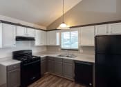 Thumbnail 10 of 26 - an empty kitchen with black appliances and white cabinets