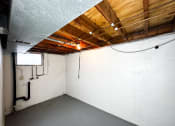 Thumbnail 19 of 26 - the inside of a basement with a white wall and wood ceilings
