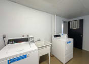 Thumbnail 11 of 15 - a laundry room with two washing machines and a sink