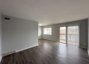 Thumbnail 3 of 15 - an empty living room with wood floors and a sliding glass door