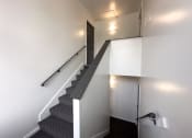 Thumbnail 10 of 15 - a stairwell in a building with white walls and stairs and a door