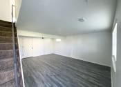 Thumbnail 8 of 26 - an empty living room with wood flooring and white walls
