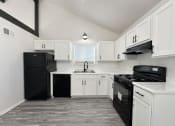 Thumbnail 1 of 26 - an empty kitchen with white cabinets and black appliances