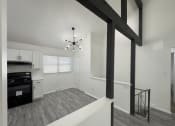 Thumbnail 3 of 26 - the living room and kitchen of an apartment with white walls and black appliances