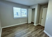 Thumbnail 13 of 22 - an empty living room with wooden floors and a window
