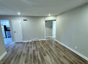 Thumbnail 16 of 22 - a living room with wooden floors and white walls
