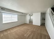 Thumbnail 1 of 12 - an empty living room with a staircase in the background