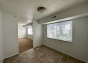 Thumbnail 3 of 12 - a bedroom with a large window and a tiled floor