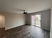 Thumbnail 6 of 17 - A room with a ceiling fan and sliding glass doors.