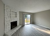 Thumbnail 2 of 8 - an empty living room with a stone fireplace