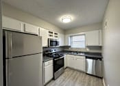 Thumbnail 4 of 8 - a kitchen with white cabinets and stainless steel appliances