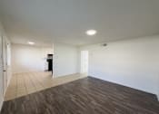 Thumbnail 4 of 15 - an empty living room with white walls and wood flooring