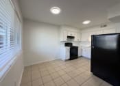 Thumbnail 3 of 15 - A kitchen with black appliances and white cabinets.