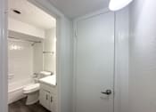 Thumbnail 9 of 19 - A white bathroom with a toilet, sink, and shower.