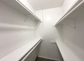 Thumbnail 8 of 19 - Empty white hallway with a carpeted floor.