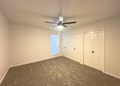 Thumbnail 7 of 19 - A room with a ceiling fan and two doors.