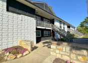 Thumbnail 1 of 6 - the front of a building with a staircase and a stone wall