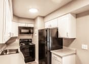 Thumbnail 11 of 23 - Kitchen with spacious cabinetry and black appliances
