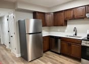 Thumbnail 20 of 39 - a kitchen with a stainless steel refrigerator and wooden cabinets