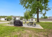 Thumbnail 18 of 25 - a picnic area with picnic tables and a tent in a park