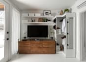 Thumbnail 10 of 12 - A modern living room with a flat screen TV and a wooden cabinet.
