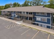 Thumbnail 12 of 14 - a blue building with balconies and a parking lot