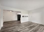 Thumbnail 3 of 14 - an empty living room with white walls and wood floors