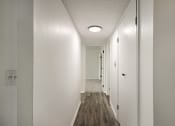 Thumbnail 5 of 14 - a hallway with white walls and wood floors