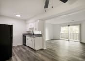 Thumbnail 1 of 14 - an empty kitchen and living room with a sliding glass door