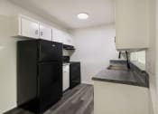 Thumbnail 2 of 14 - a kitchen with a black refrigerator and a sink
