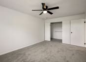Thumbnail 8 of 14 - an empty living room with a ceiling fan and white walls