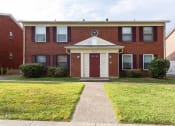 Thumbnail 9 of 15 - a red brick house with a sidewalk in front of it
