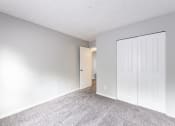 Thumbnail 6 of 15 - a bedroom with a closet and a door to a hallway