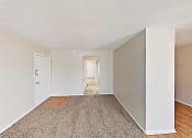 Thumbnail 5 of 15 - an empty living room with wood flooring and white walls