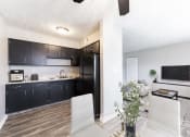 Thumbnail 1 of 15 - a kitchen and living room with a black refrigerator
