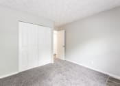 Thumbnail 7 of 15 - a bedroom with a white door and carpeted floor